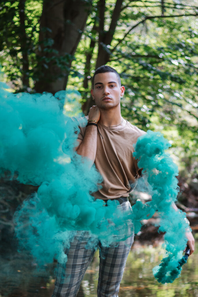 Man waving colored smoke around in nature