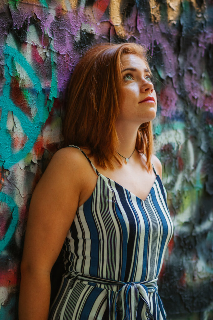 Woman in jumpsuit in front of graffiti