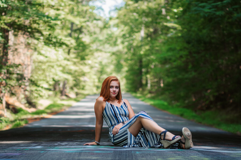 Woman sitting in road posing for portrait